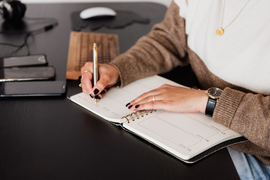 Woman writing in a planner at her desk